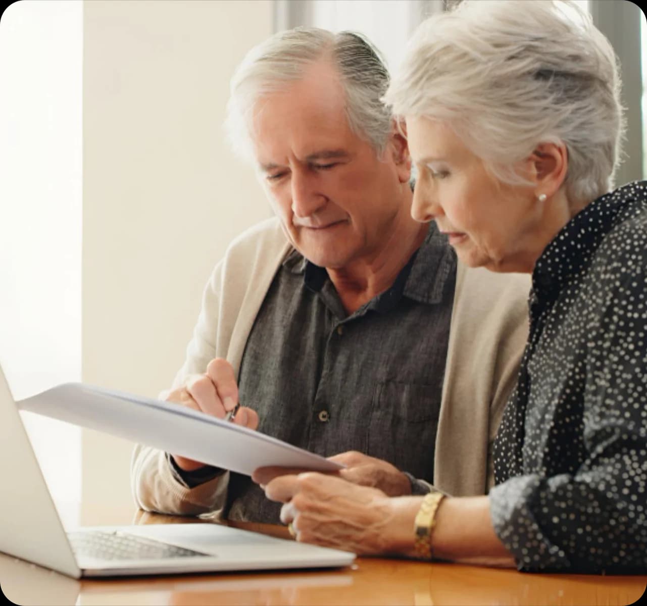 Long Term Care Insurance - Elderly couple reviewing documents on laptop