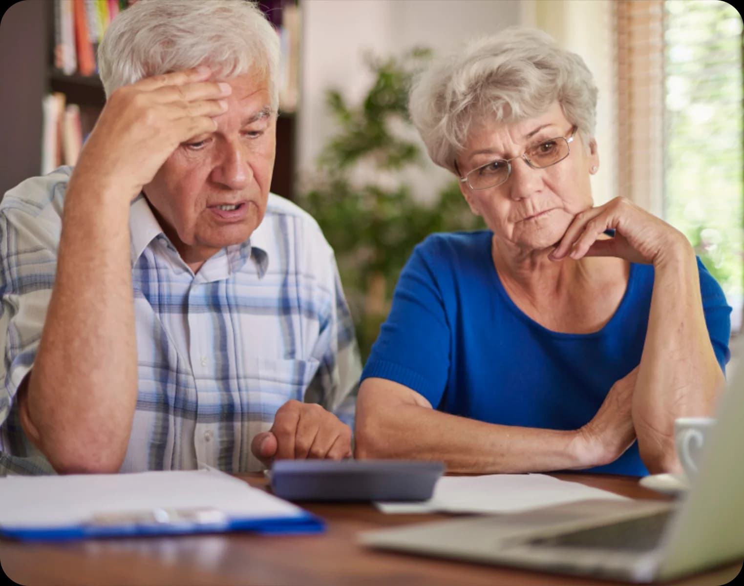 What Medicare Does and Does Not Cover - Stressed elderly couple reading papers